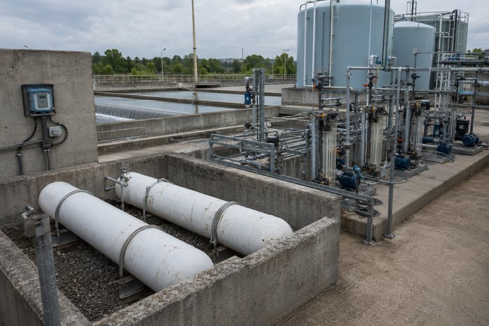 Área de dosificación química de planta potabilizadora con cilindros de cloro en contención y bombas dosificadoras.