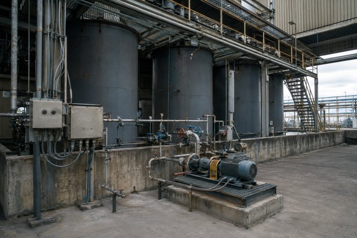 Tanques de solvente en dique de contención con skid de bombeo y envolventes eléctricos.
